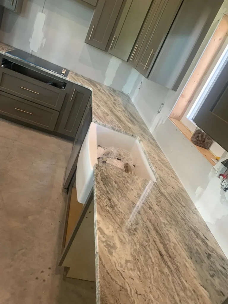 A kitchen under construction with granite tabletop
