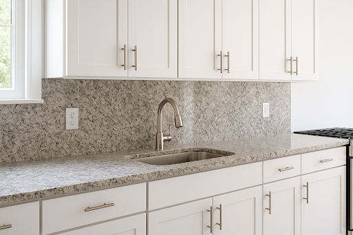 Granite backsplash with matching countertop in a bright kitchen. These stones are ideal for busy kitchens and homes that enjoy entertaining.